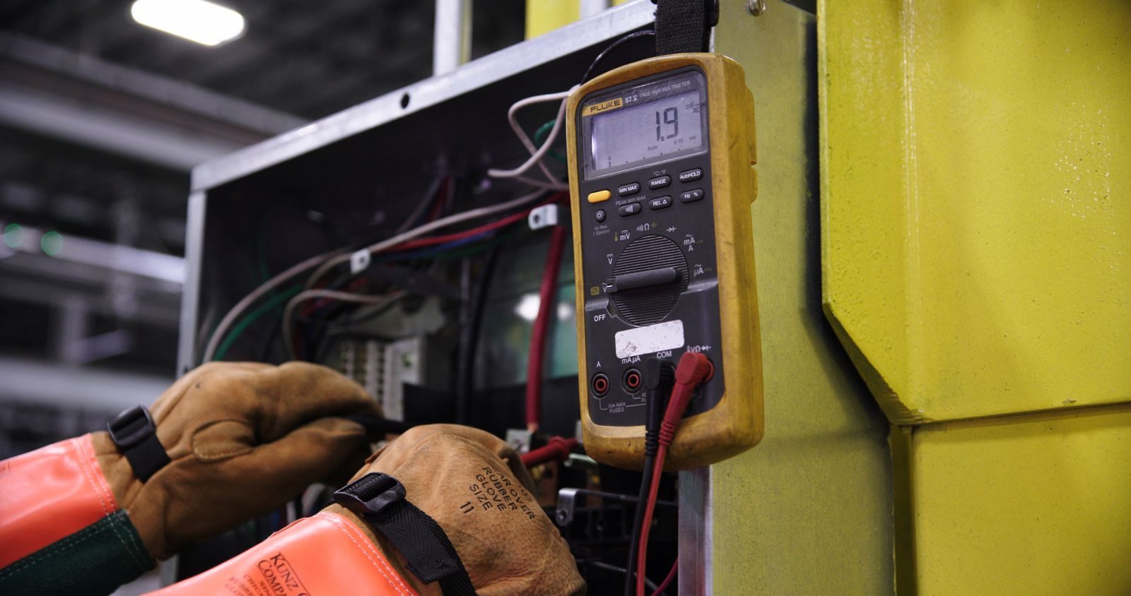 Technician testing an electrical panel with instruments